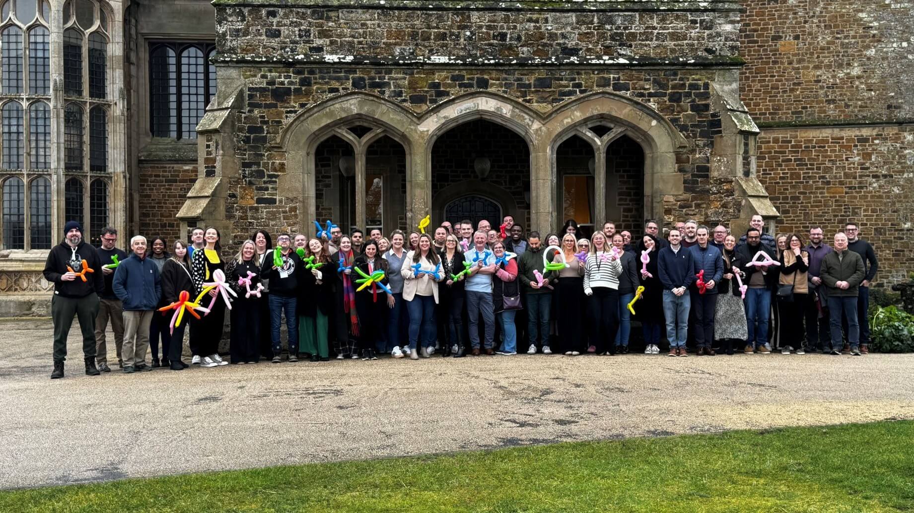 Embridge Consulting Team Pink group photo with balloon animals.